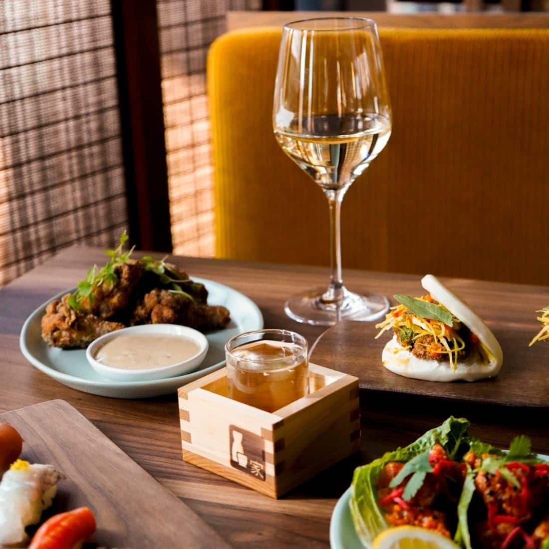 table spread with sushi, karaage, wine and sake